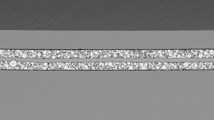 SEM image of the full Li-NMC electrode sample, showing the two porous layers and the metal film at the center of the structure. SEM image of the full Li-NMC electrode sample, showing the two porous layers and the metal film at the center of the structure.